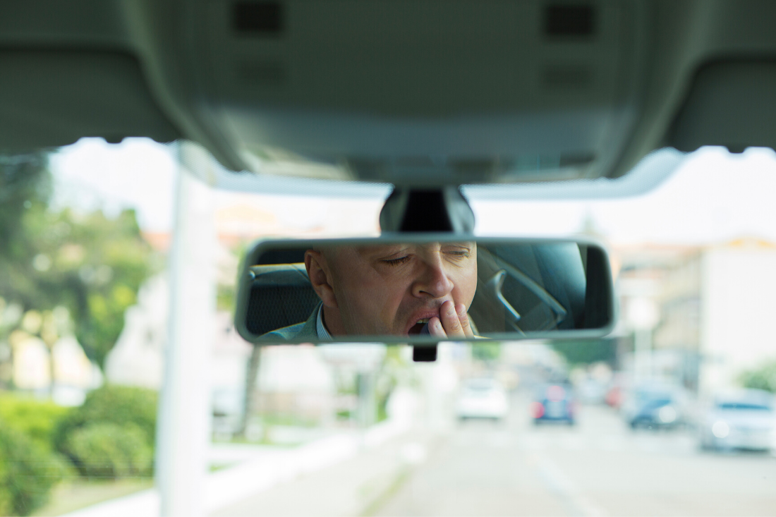 Homme qui baille dans le rétrovisieur